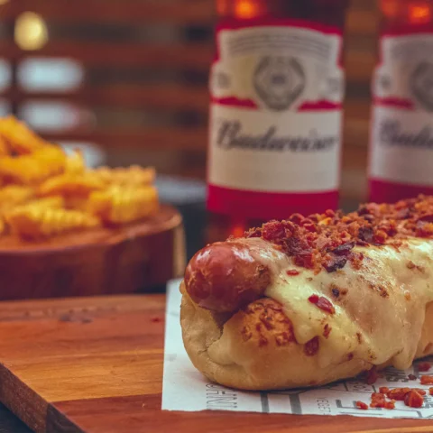 Close-up of a hot dog covered in melted cheese and bacon.