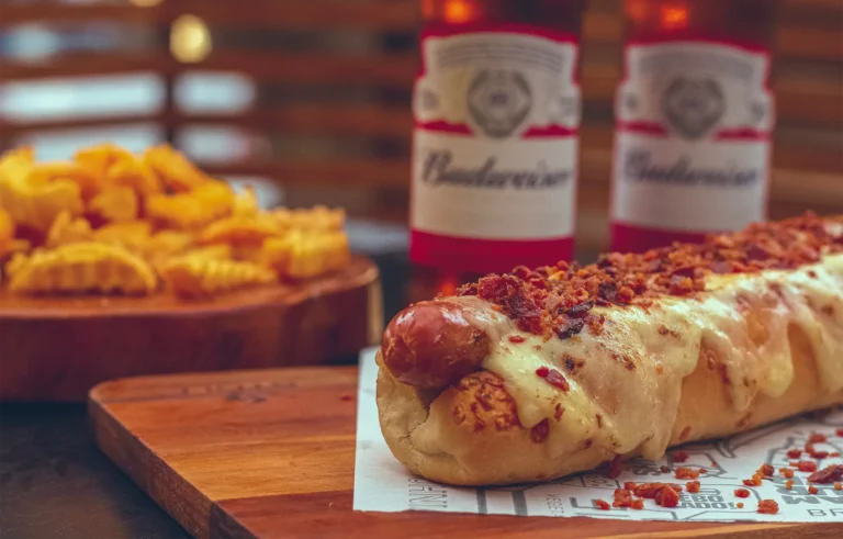Close-up of a hot dog covered in melted cheese and bacon.