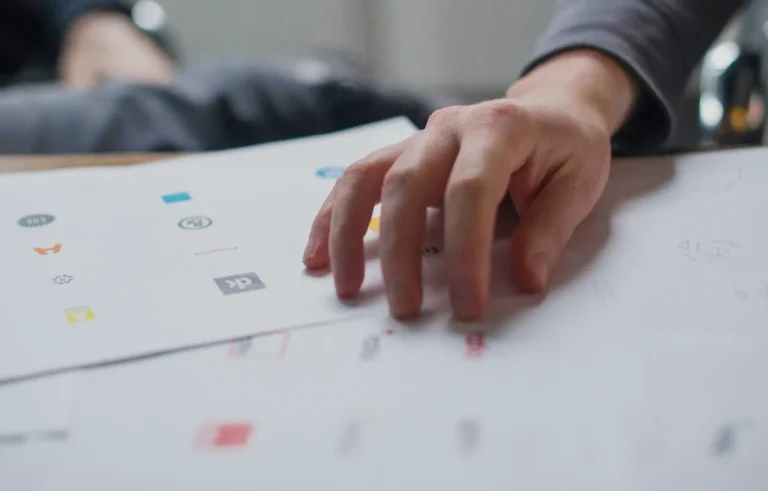 man reviewing multiple logo proposals